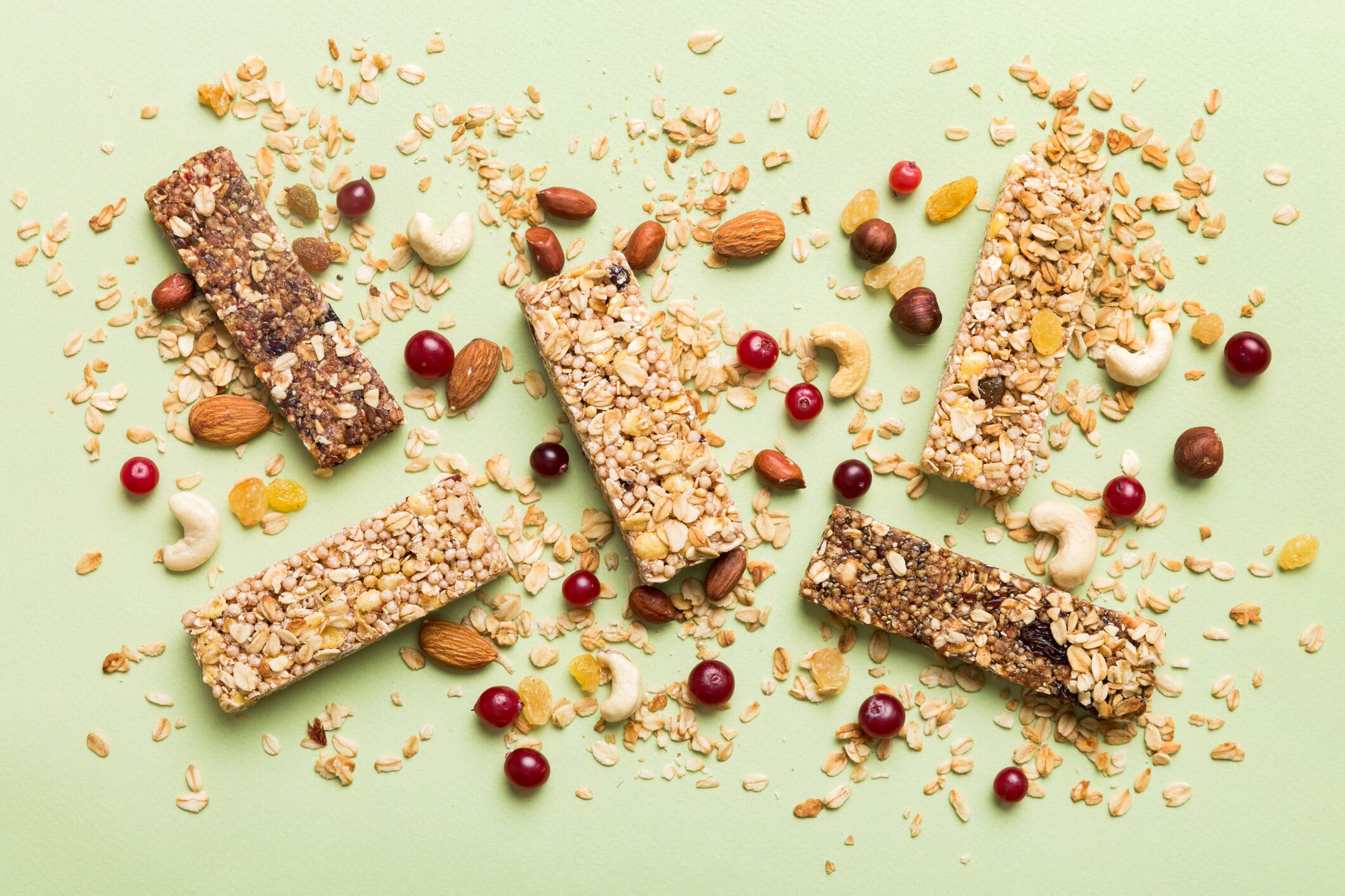 A new trend is hitting the aisles: minimally processed snacks. Various granola bars on table background. Cereal granola bars. Superfood breakfast bars with oats, nuts and berries, close up. Superfood concept.
