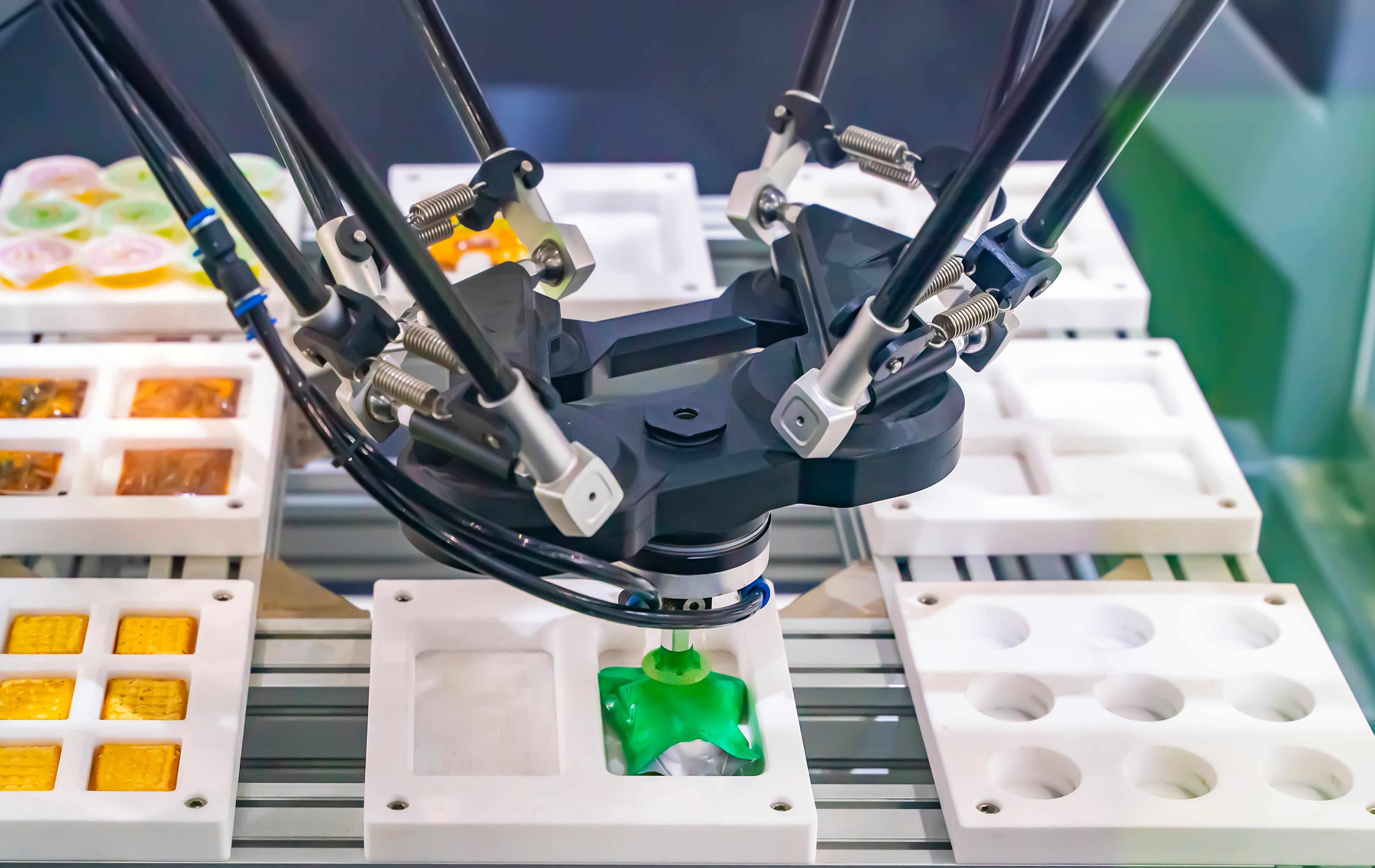 A robot fills a mould with jelly sweets