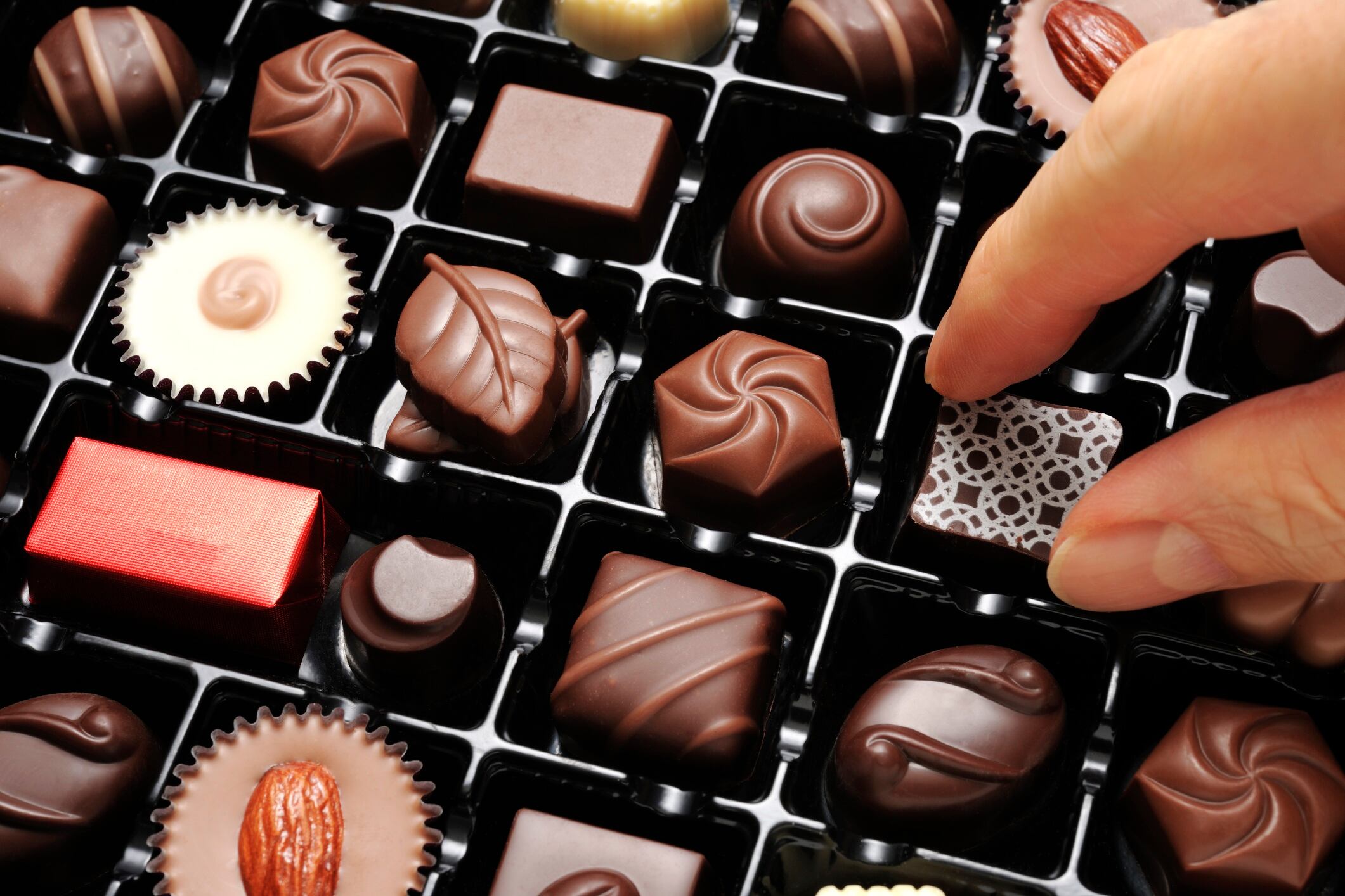 High angle view of choosing a chocolate from a box.