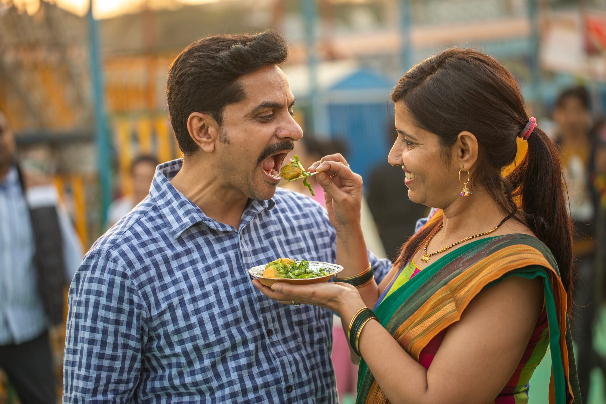 Indian couple enjoying sev puri at a festival