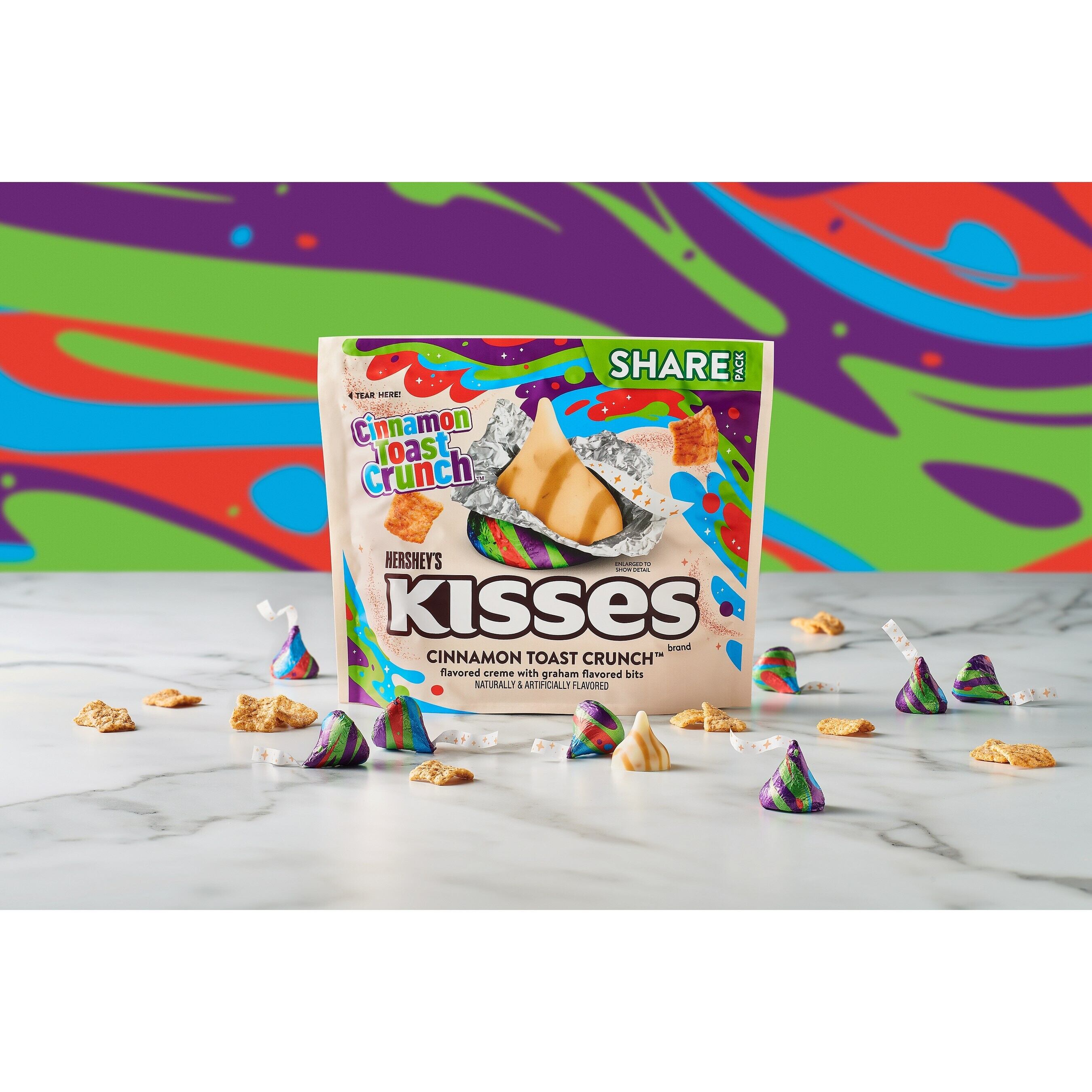 Hershey's Kisses cinnamon toast crunch flavoured candies against a rainbow background.