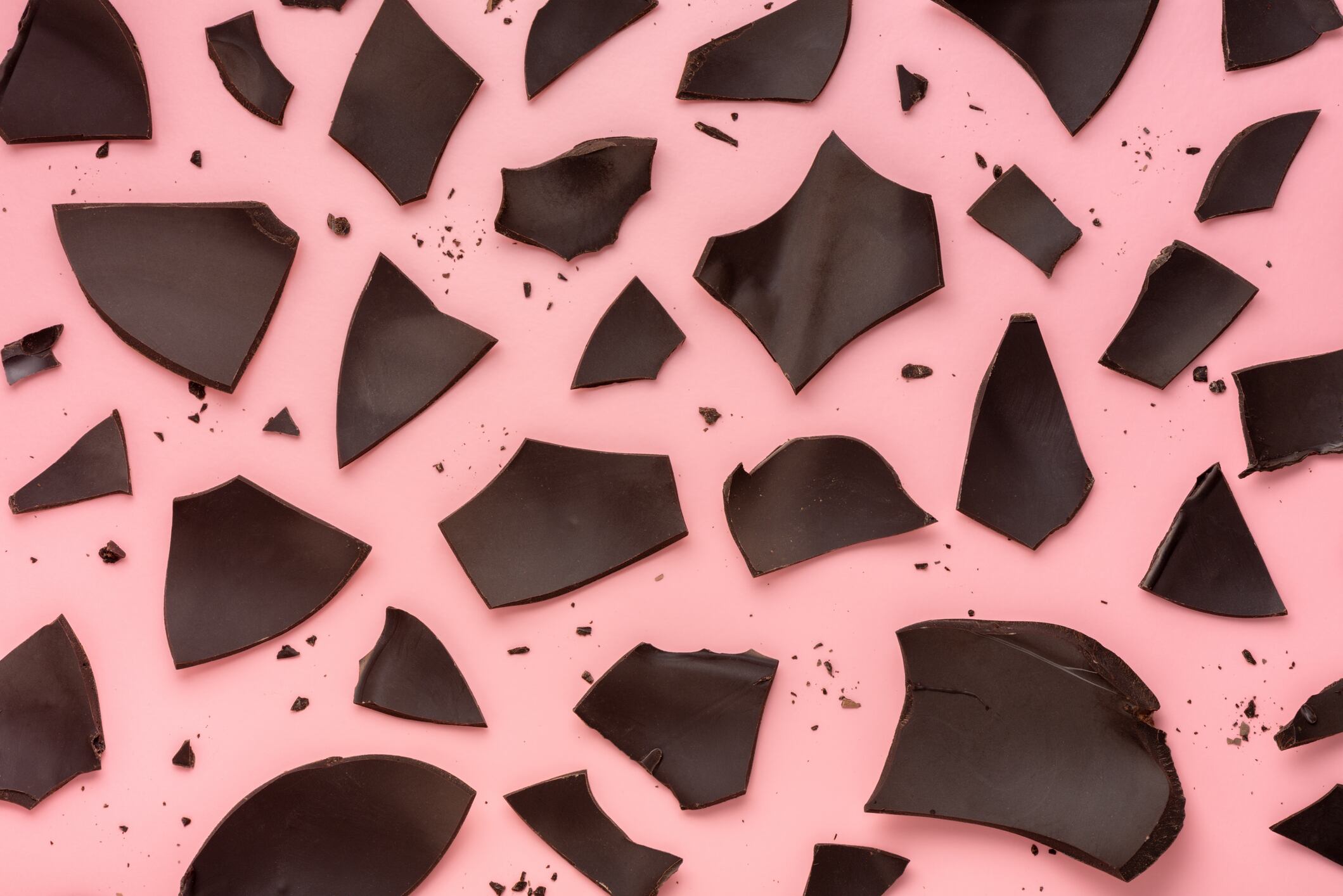 exploded chocolate Easter egg over pink background, holiday concept