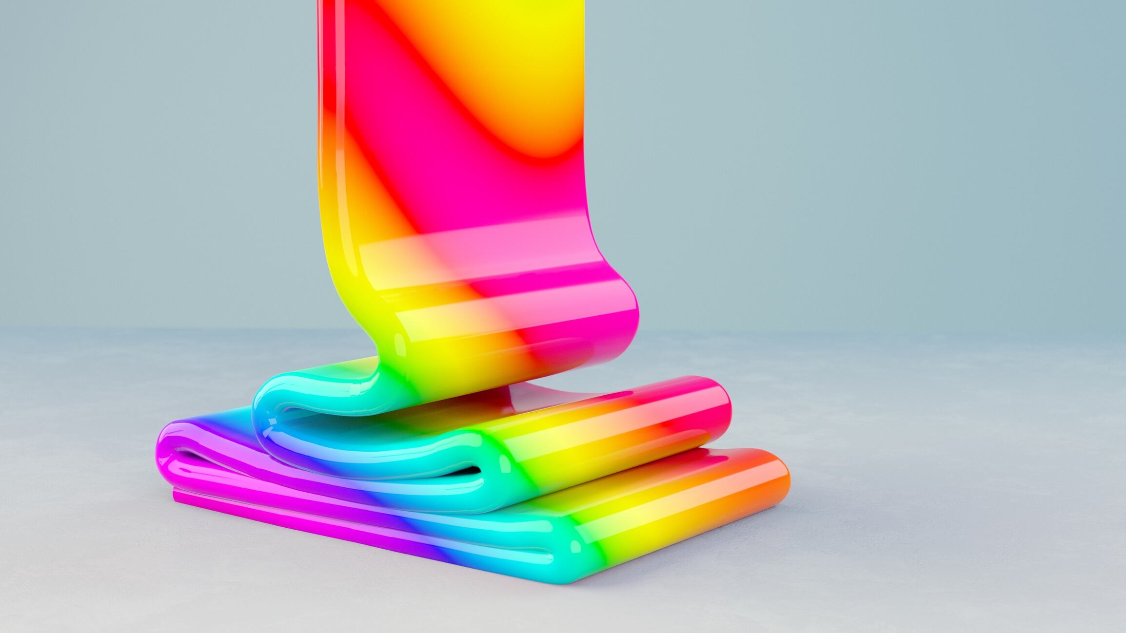 Rainbow coloured paste poured on a grey surface.