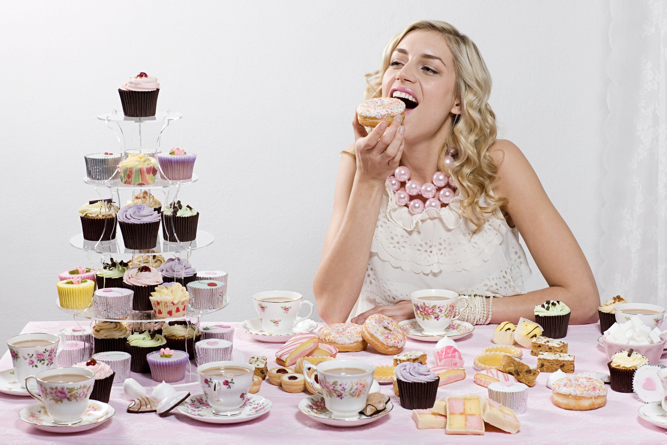 Woman indulging in doughnuts and cakes