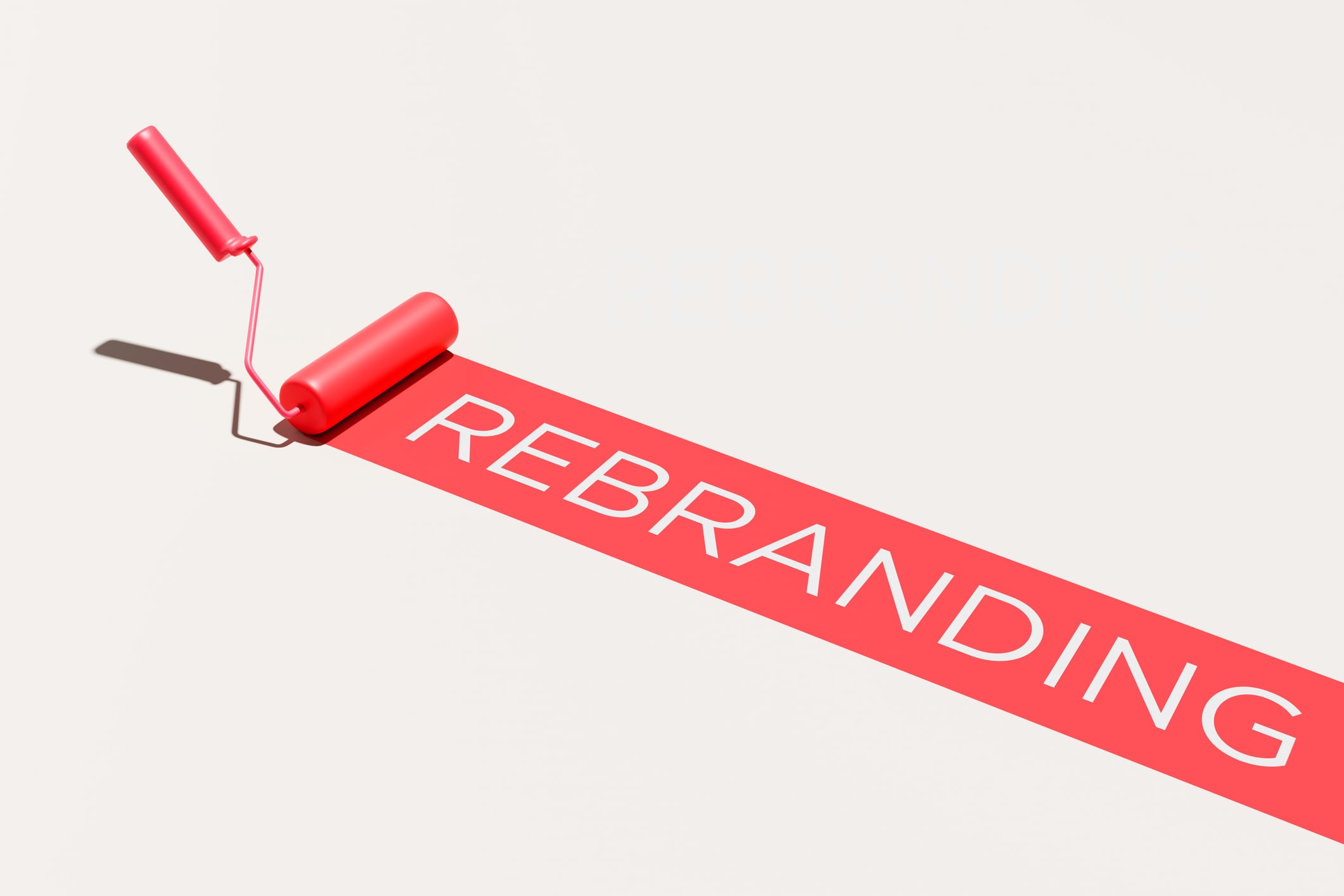Paint roller painting a red stripe with the word REBRANDING on a white surface, concept for business transformation, fresh start and corporate identity change