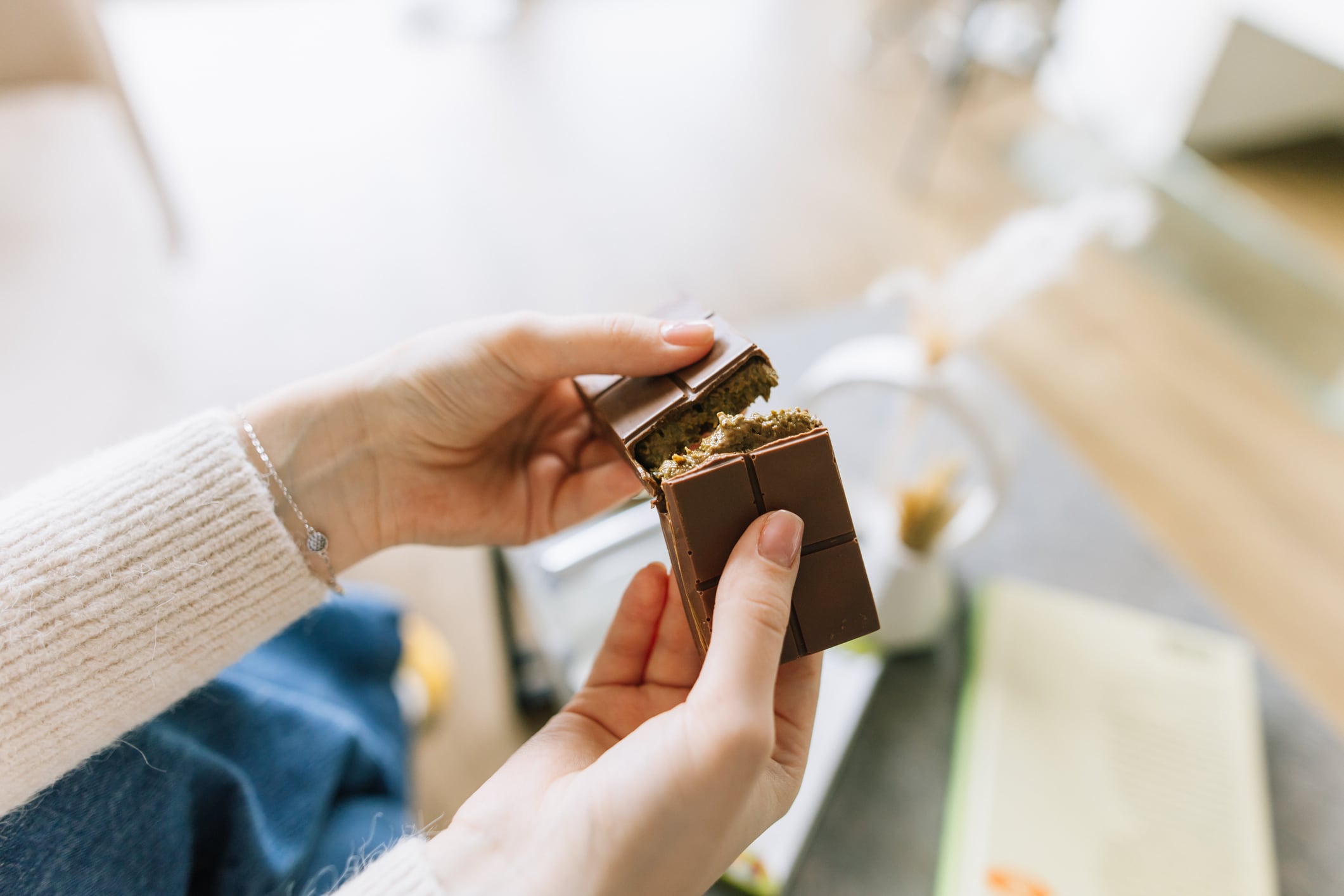 Close-up view of woman's hands breaks the Dubai chocolate bar