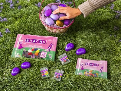 Brach's Easter eggs on grass with a hand reaching for some in a basket.