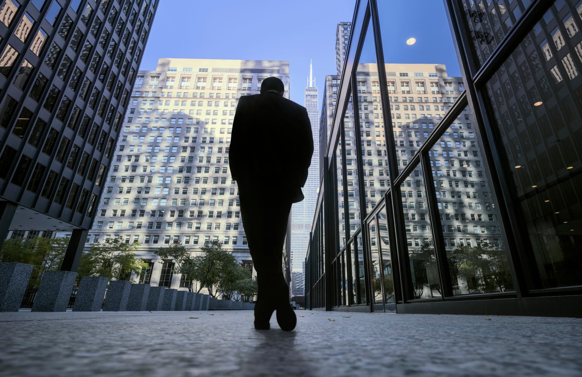 Sunny morning at central business district of Chicago with silhouette of businessman.