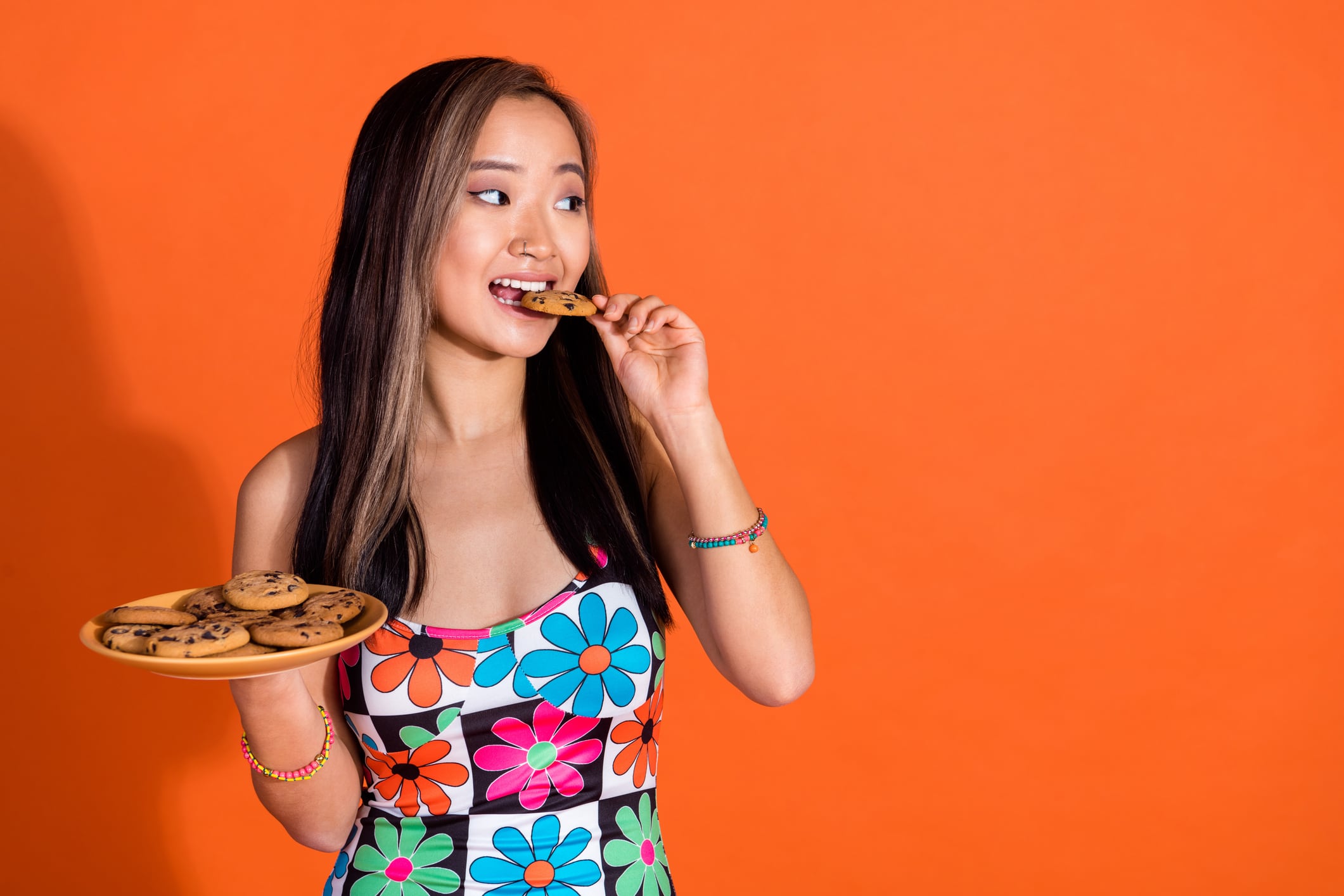 Woman eating a cookie and holding more