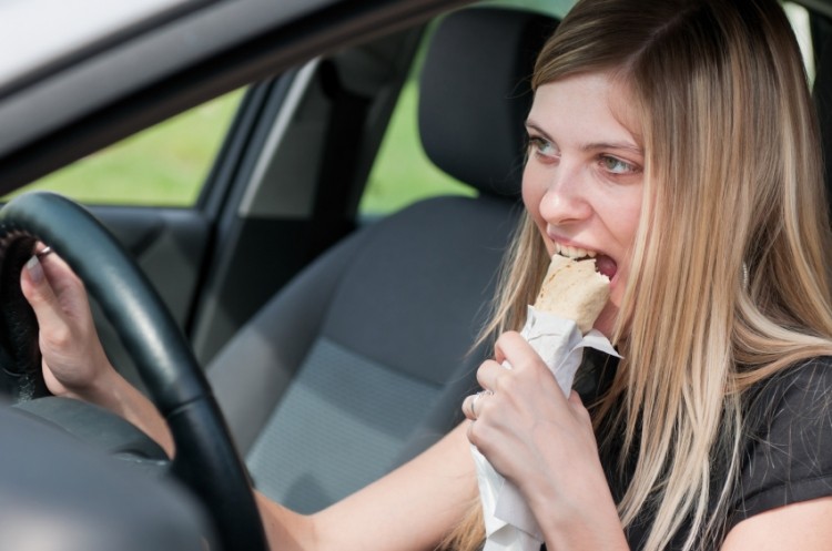 University of Surrey research says distractions created by eating at the desk or in the car can lead to overeating