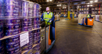 A volunteer at one of Fareshare's warehouses loads up tins of Cadbury Heroes for redistribution this Christmas. Pic: Mondelēz International